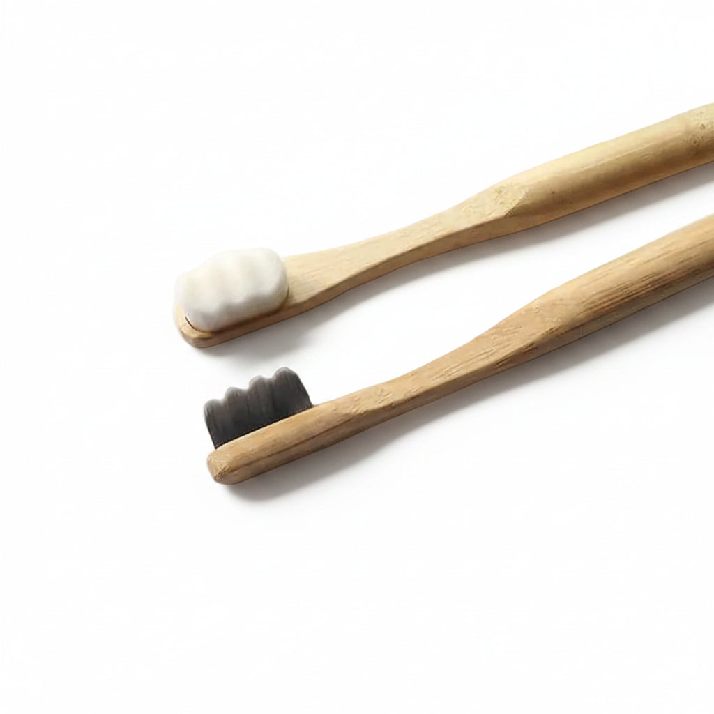 Close-up view of Liveify natural bamboo toothbrushes featuring wavy white and nano charcoal black soft bristles