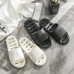 Liveify white and black home slippers with breathable holes, soft sole, on marble floor near pajamas