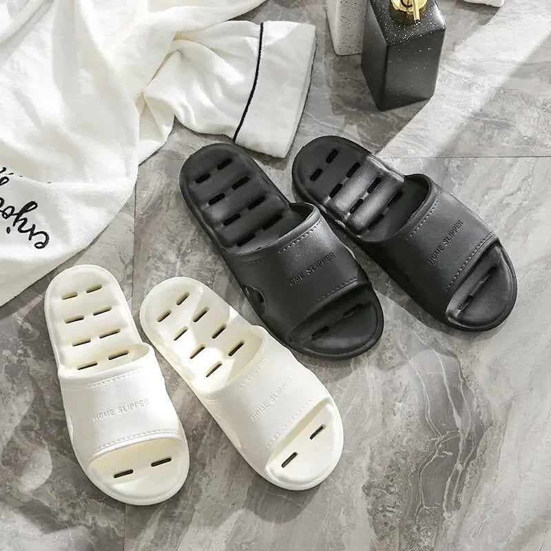 Liveify white and black home slippers with breathable holes, soft sole, on marble floor near pajamas