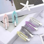 Liveify pearl and rhinestone hair clips in pink, blue, purple, gray, and yellow, styled on white marble with starfish decor