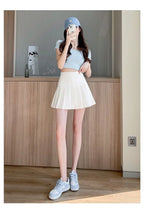 Liveify woman wearing light blue crop top, white pleated tennis skirt, matching sneakers, and denim cap for casual summer outfit