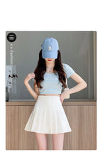 Liveify light blue baseball cap with embroidered R, worn with crop top and white pleated skirt