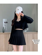 Liveify black pleated mini skirt with cropped top and white cap, stylish new season must-have