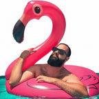 Liveify pink inflatable flamingo pool float with black beak, man relaxing in pool