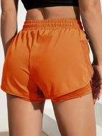 Liveify orange athletic shorts with mesh side pocket, elastic waist, and layered hem for gym or running