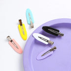 Liveify pastel hair clips in pink, yellow, blue, white, black, and purple on a purple plate