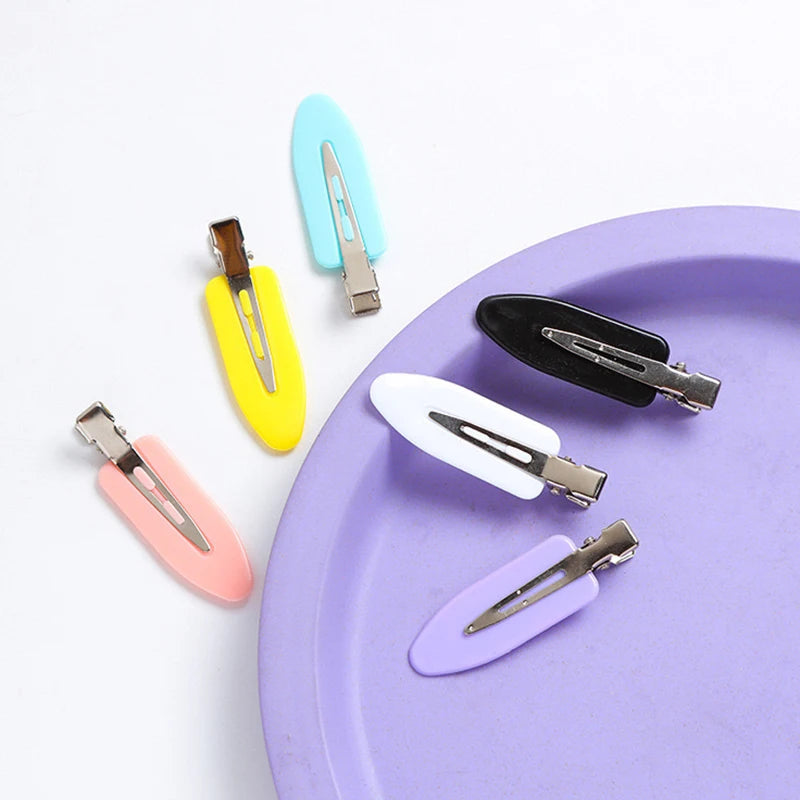 Liveify pastel hair clips in pink, yellow, blue, white, black, and purple on a purple plate