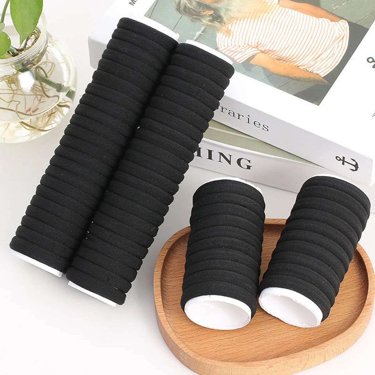 Liveify black ribbed hair ties with white ends, displayed on wood tray and books, stylish elastic ponytail holders