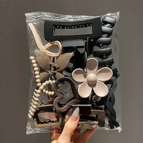Liveify assorted hair claw clips in black, beige, and brown with flower, butterfly, and beaded designs in clear packaging