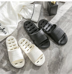 Liveify white and black home slippers with ventilation holes, soft material, and indoor comfort design on marble floor