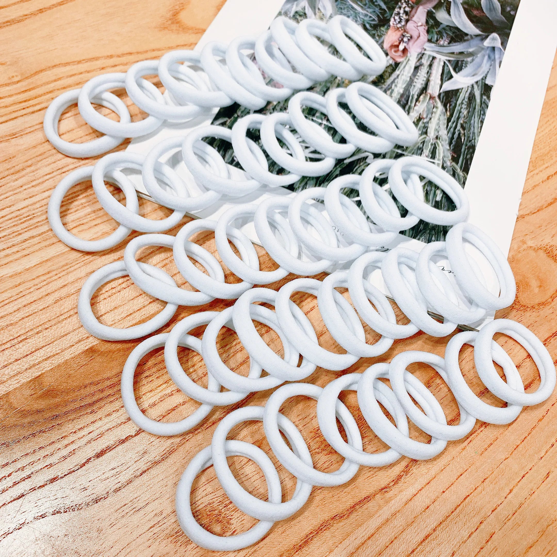 Liveify white silicone hair ties on wooden surface, soft and stretchy for everyday use