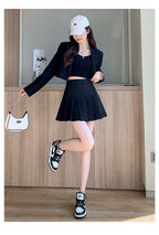 Liveify black pleated mini skirt with matching blazer, white cap, and Nike sneakers for trendy streetwear look