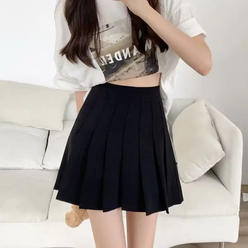 Liveify black pleated mini skirt with high waist, worn with white crop top, casual style