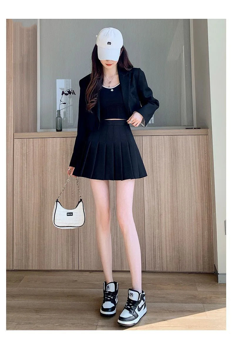Liveify black pleated mini skirt with blazer, white cap, and sneakers outfit