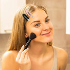 Liveify black makeup brush with dense bristles, used for applying powder or blush, shown with pink and black hair clips in hair