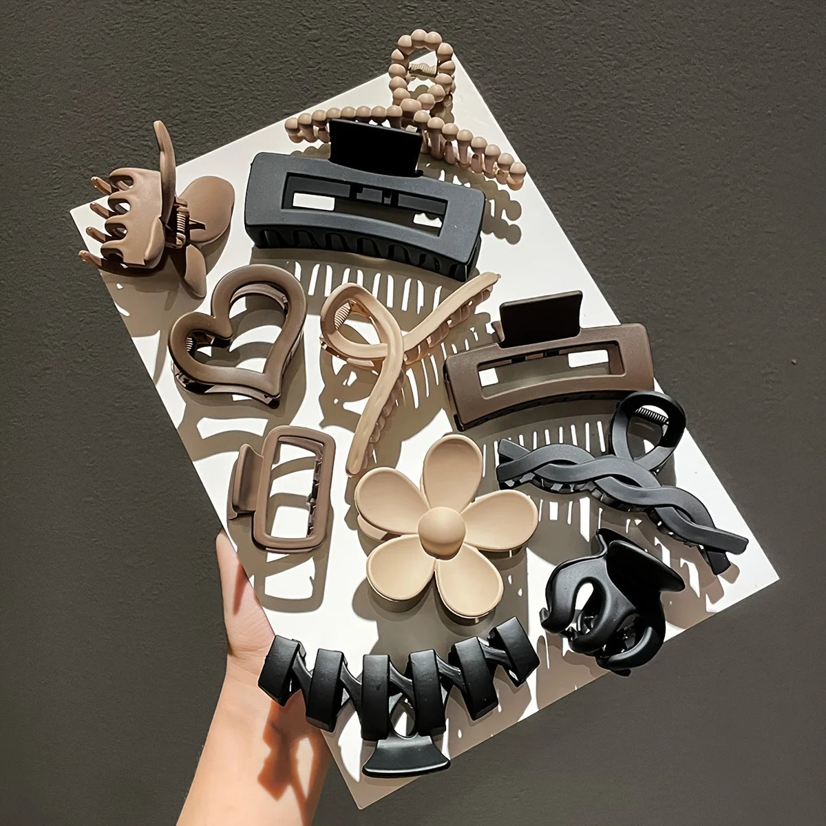Liveify assorted hair clips in black, beige, and brown with heart, flower, and twisted designs on white tray
